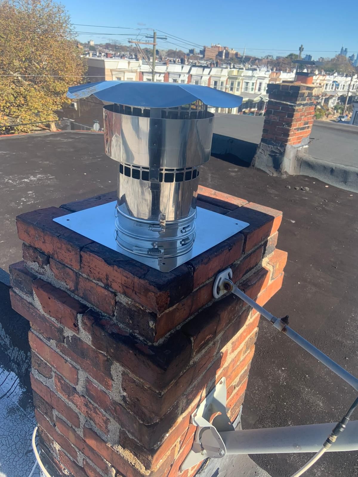 "A professional repairing the flashing of a brick chimney."